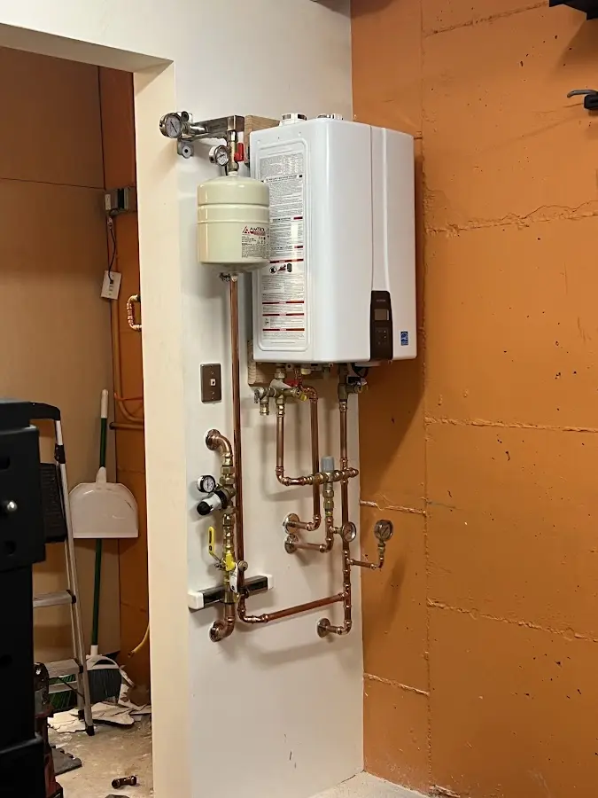 Plumbing technician inspecting water heater connections in Glasgow